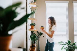 Young woman holding one of her indoor plants.