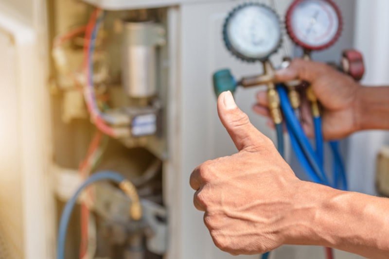 Close up of HVAC repairman on the floor fixing air conditioning system.